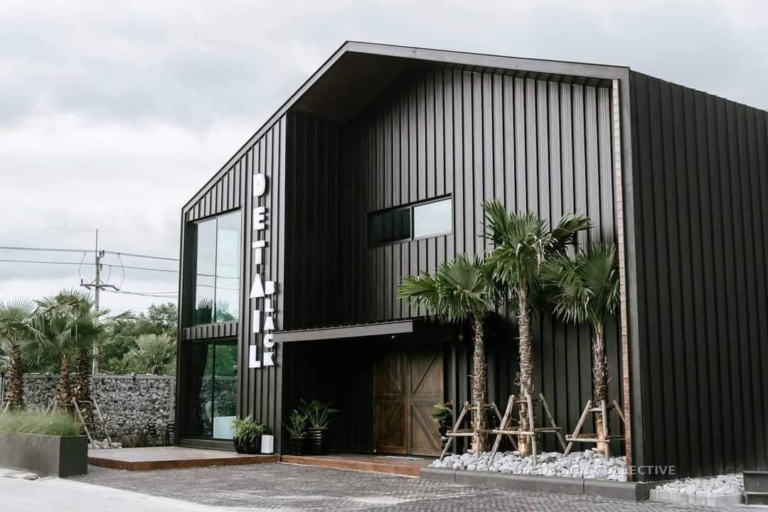 Black vertical-clad commercial warehouse building with glazed office frontage